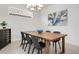 Modern dining room with a wooden table, black chairs, chandelier and elegant decor at 5709 Puccini St, Nokomis, FL 34275