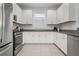 Modern kitchen with stainless steel appliances, white cabinetry, and granite countertops at 5709 Puccini St, Nokomis, FL 34275