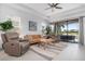 Bright living room features tile flooring, sliding glass doors to outdoor lanai, and comfortable seating at 5709 Puccini St, Nokomis, FL 34275