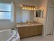 Double vanity bathroom with a large garden tub and updated light fixtures at 5116 Brooksbend Cir, Sarasota, FL 34238