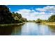 Serene waterfront view with lush greenery and blue skies at 5116 Brooksbend Cir, Sarasota, FL 34238