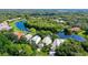 Beautiful aerial view showcasing a home with mature trees and a serene lake, offering a private oasis at 7217 Churston Ln, University Park, FL 34201