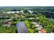 Aerial view of a beautiful property with a large lake, surrounded by lush landscaping and mature trees at 7217 Churston Ln, University Park, FL 34201