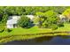 Aerial view of a private backyard with a screened pool, lush greenery, and a serene lake at 7217 Churston Ln, University Park, FL 34201