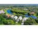 Stunning aerial view showcasing a home with mature trees and a serene lake, offering a private oasis at 7217 Churston Ln, University Park, FL 34201