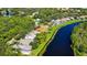 Aerial view of a property bordering a lake, showcasing a well-maintained lawn and mature trees at 7217 Churston Ln, University Park, FL 34201