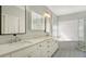 Bright bathroom featuring dual sinks, marble counters, decorative tile floors, soaking tub, and glass enclosed shower at 7217 Churston Ln, University Park, FL 34201