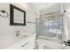 Bright bathroom with a modern vanity, decorative tile, and a shower-tub combo with a glass door at 7217 Churston Ln, University Park, FL 34201