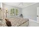 Bedroom featuring plantation shutters, a decorative bed frame, and neutral-colored walls at 7217 Churston Ln, University Park, FL 34201