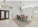 Open dining area with high ceilings, a modern chandelier, and views of the entryway and kitchen at 7217 Churston Ln, University Park, FL 34201