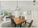 Open dining area with pool views, a modern chandelier, and views of the entryway and living area at 7217 Churston Ln, University Park, FL 34201