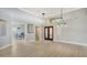 Bright foyer with high ceilings, chandelier lighting, and wooden double-door entry at 7217 Churston Ln, University Park, FL 34201