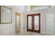 View of a house's front entrance showcasing the front door, a mirror, neutral walls, and white window shutters at 7217 Churston Ln, University Park, FL 34201