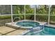 Close-up of the in-ground hot tub adjacent to a swimming pool and patio area, surrounded by lush landscaping at 7217 Churston Ln, University Park, FL 34201