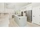 Bright kitchen featuring white cabinets, stainless steel appliances, and a large island with gas cooktop at 7217 Churston Ln, University Park, FL 34201