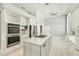 Bright kitchen featuring white cabinets, stainless steel appliances, and a large island with gas cooktop at 7217 Churston Ln, University Park, FL 34201