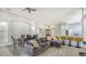 Open-concept living area showcasing a gray sectional, dining table, and kitchen island with bar stools at 7217 Churston Ln, University Park, FL 34201