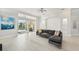 Bright living room with access to the pool area through glass doors, featuring a comfortable gray sectional at 7217 Churston Ln, University Park, FL 34201