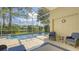 Indoor/outdoor pool and patio with view of lake, surrounded by lush landscaping and covered by a screened enclosure at 7217 Churston Ln, University Park, FL 34201