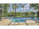 Enclosed pool and patio, with a view of the lake and landscaping through the screen and lush outdoor foliage at 7217 Churston Ln, University Park, FL 34201