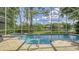 Screened-in pool area with a pool, spa, and tranquil pond view with mature landscaping at 7217 Churston Ln, University Park, FL 34201