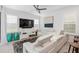 Bright living room featuring white leather sectional sofa and large TV at 8370 Velda Trl, Sarasota, FL 34241