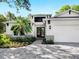 Modern two-story house with white exterior, three car garage, and paver driveway at 2246 Webber St, Sarasota, FL 34239