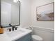 Modern powder room with a blue vanity, a frameless mirror, and beach-themed art at 2246 Webber St, Sarasota, FL 34239