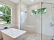 Spa-like bathroom with a soaking tub, walk in shower, and window at 2319 Webber St, Sarasota, FL 34239