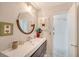 Updated bathroom with a floating vanity, round mirror, and stylish fixtures at 2488 Breakwater Cir, Sarasota, FL 34231