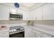 Updated kitchen featuring white cabinets and quartz countertops at 2488 Breakwater Cir, Sarasota, FL 34231