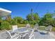 Relaxing patio with white metal furniture and lush green surroundings at 2488 Breakwater Cir, Sarasota, FL 34231