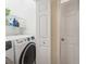 Convenient laundry room with washer, dryer, and shelving at 4951 Lakescene Pl, Sarasota, FL 34243