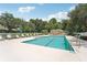 Community swimming pool with lounge chairs and umbrellas at 4951 Lakescene Pl, Sarasota, FL 34243