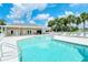 Community pool with covered patio and lounge chairs at 4072 Fairway Pl, North Port, FL 34287