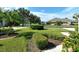 Landscaped front yard with lush lawn and palm trees at 4072 Fairway Pl, North Port, FL 34287