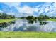 Serene lake view with lush landscaping and homes in the background at 4072 Fairway Pl, North Port, FL 34287