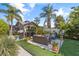 Relaxing backyard patio with covered seating area, artificial turf, and tropical landscaping at 4108 101St W St, Bradenton, FL 34210