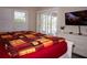 Bedroom with king-size bed, TV, and sliding doors to patio at 6772 Greenview Ln, Englewood, FL 34224