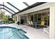 Screened pool and patio area with seating and grill at 6772 Greenview Ln, Englewood, FL 34224