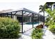 Private screened pool and patio area with lush landscaping at 6772 Greenview Ln, Englewood, FL 34224