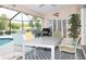 Outdoor patio with table and chairs, adjacent to the refreshing pool at 6772 Greenview Ln, Englewood, FL 34224