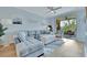 Bright living room with L-shaped sectional sofa, ottoman, and access to balcony at 4126 Central Sarasota Pkwy # 2026, Sarasota, FL 34238