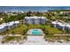 Aerial view of beachfront community with pool and lush landscaping at 4825 Gulf Of Mexico Dr # 105, Longboat Key, FL 34228
