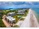 Aerial view of beachfront community with tropical landscaping at 4825 Gulf Of Mexico Dr # 105, Longboat Key, FL 34228
