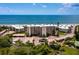 Aerial view of beachfront condo building with parking and ocean views at 4825 Gulf Of Mexico Dr # 105, Longboat Key, FL 34228