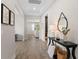 Hallway with wood-look floors, console table, and view into living room at 7291 Great Egret Blvd, Sarasota, FL 34241