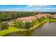 Scenic exterior view of a home near a lake, surrounded by mature trees and landscaping at 8106 Miramar Way, Lakewood Ranch, FL 34202