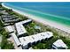 Aerial view of beachfront condo community with pool and lush landscaping at 5757 Gulf Of Mexico Dr # 109, Longboat Key, FL 34228