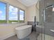 Spa-like bathroom with soaking tub, walk-in shower, and large window at 705 Jungle Queen Way, Longboat Key, FL 34228